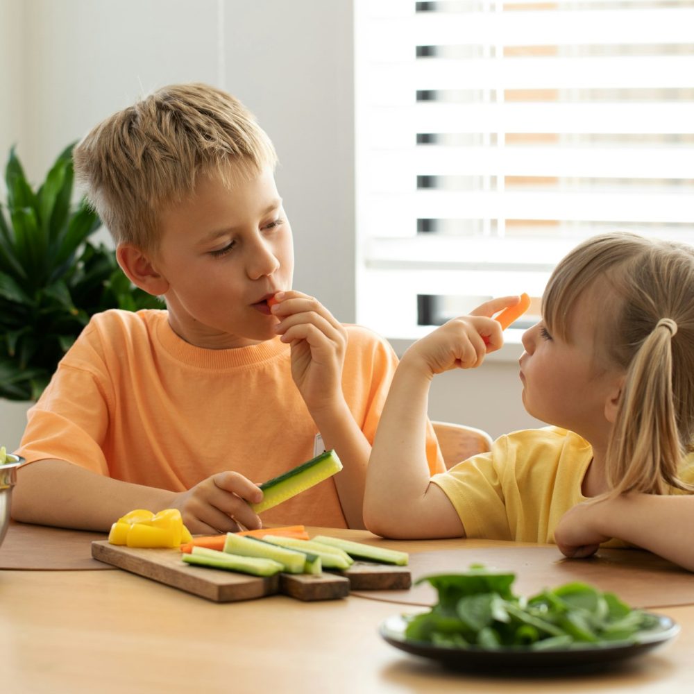 Children take sticks of fresh sticks of carrots and cucumbers. Healthy eating.