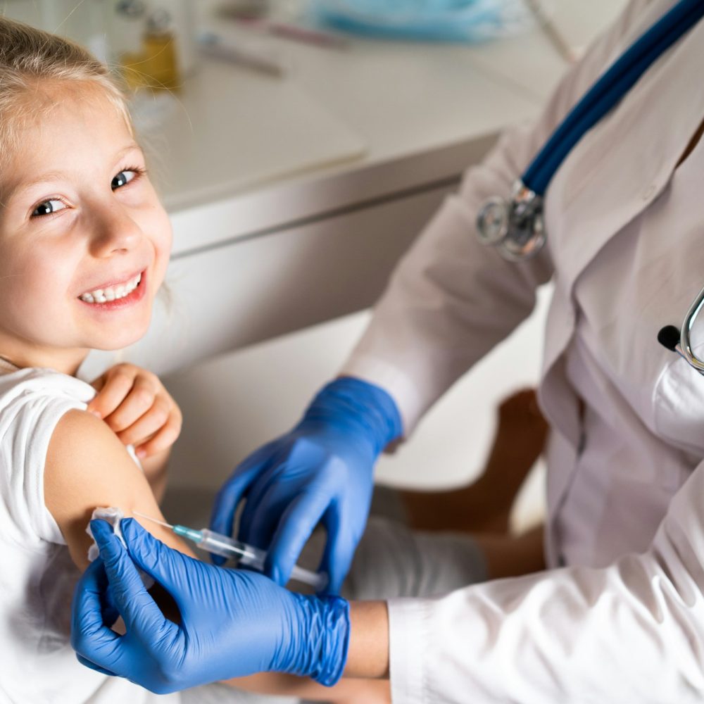 vaccination of children, a little girl at a doctor's appointment, an injection in the arm, the conce